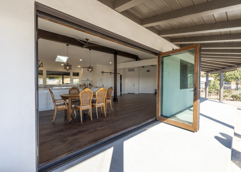Large sliding accordion patio doors open to the backyard in a home remodel project