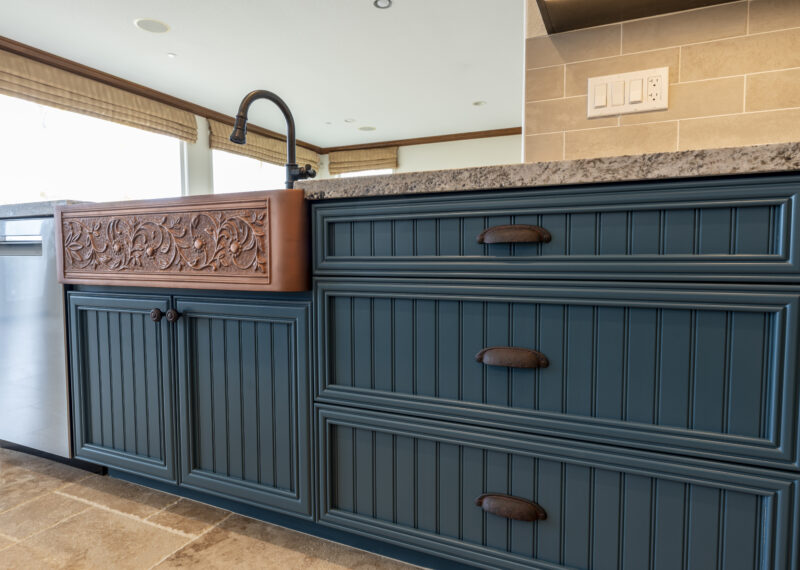Apron front double sink and custom blue cabinets with pocket pulls