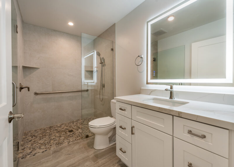 Modern bathroom with LED light up mirror and walk in shower.