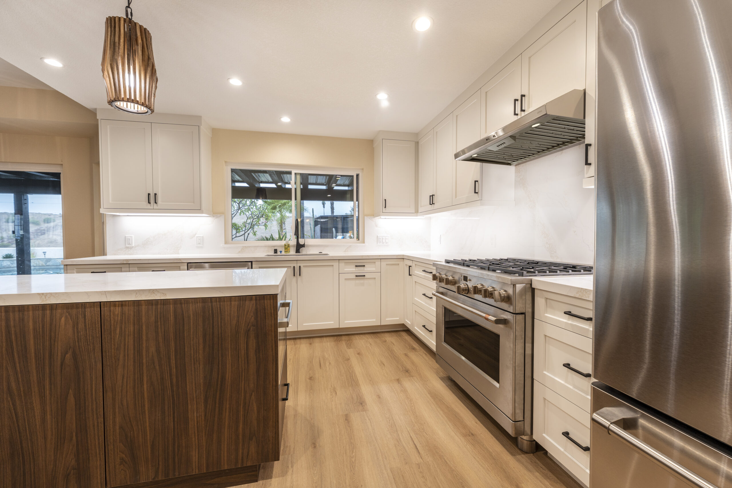 New light fixtures, custom island, warm wood floors, and an open layout kitchen remodel