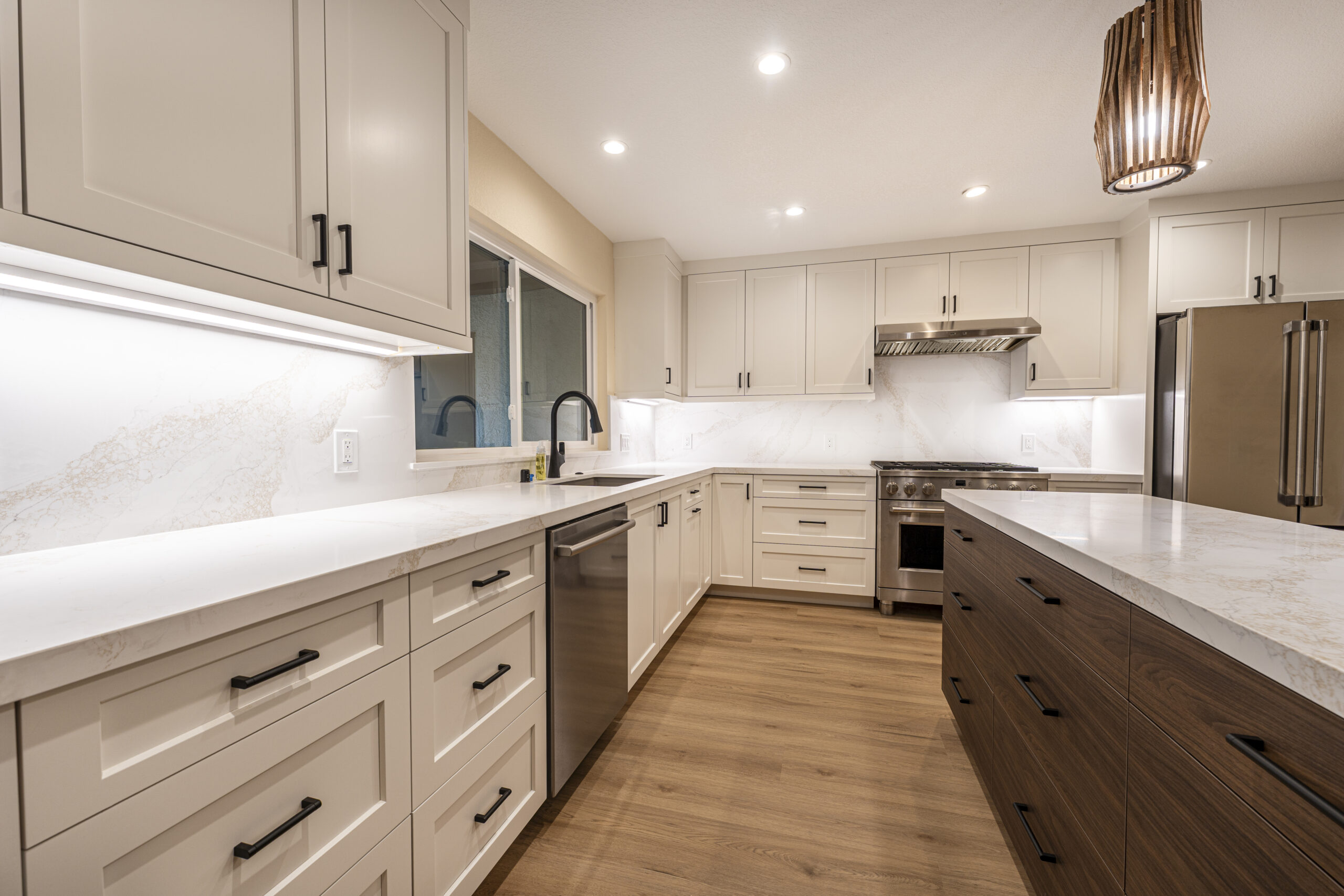 Full kitchen remodel with can lighting, new windows, and stainless steel appliances