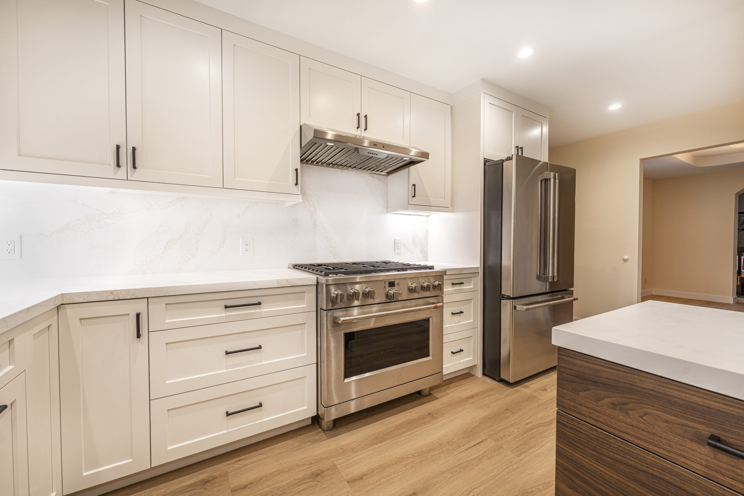 Bright, white cabinets, quartz countertops, and under cabinet lighting in this kitchen remodel