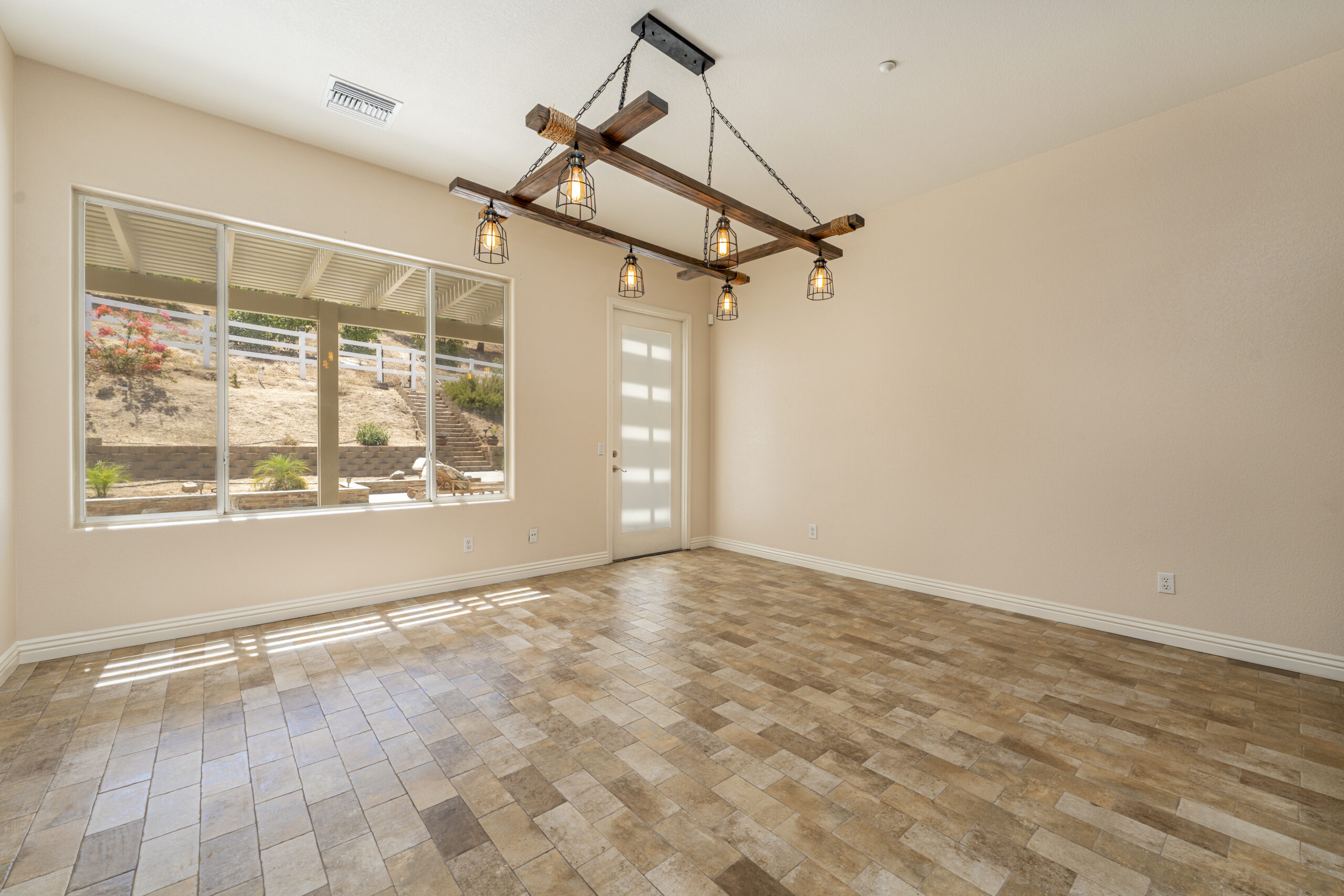 Large, open dining room remodel with custom light fixtures and large picture window.