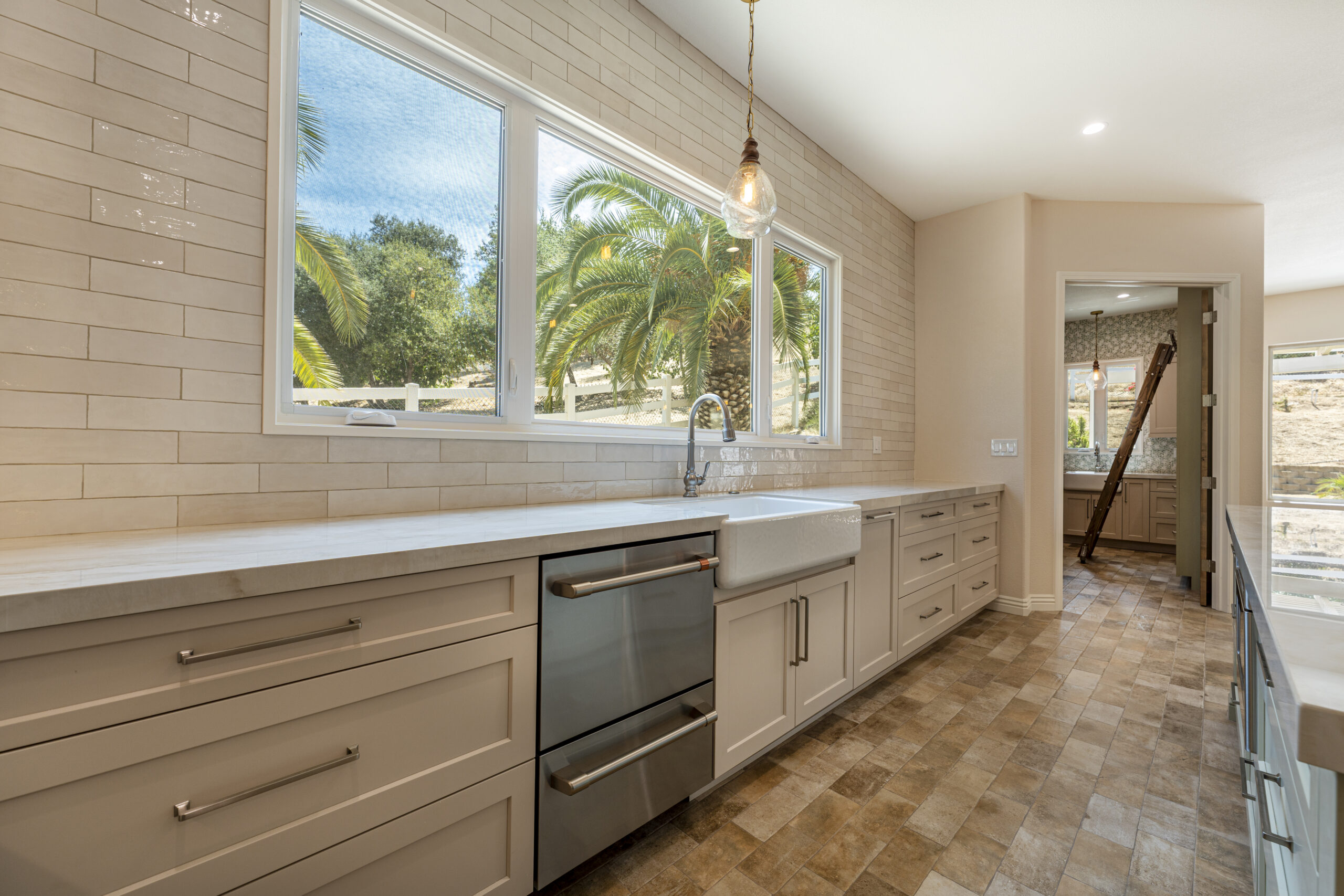 Large picture window above the farmhouse sink and spacious new countertops.
