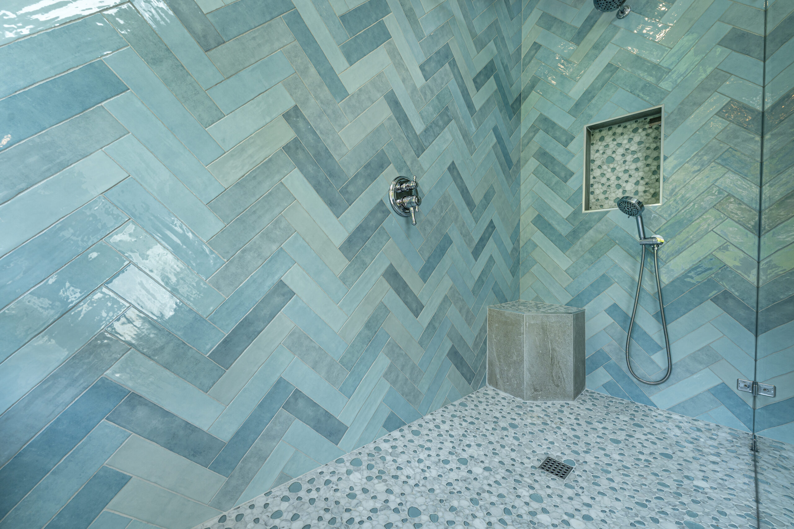 Floor to ceiling herringbone tile in this luxurious walk-in shower.