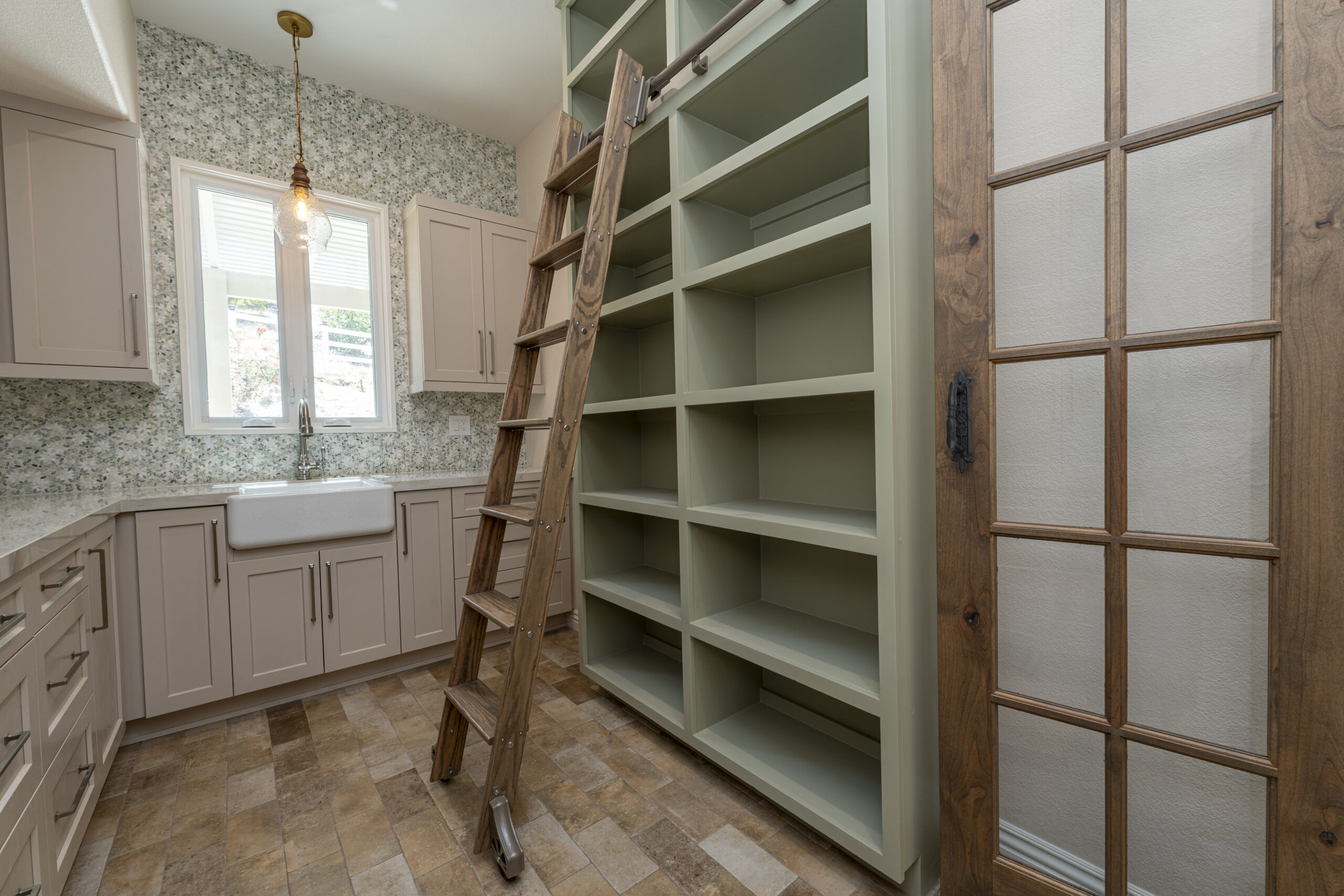 Walk in pantry with open shelves and sliding pantry ladder for easy access.
