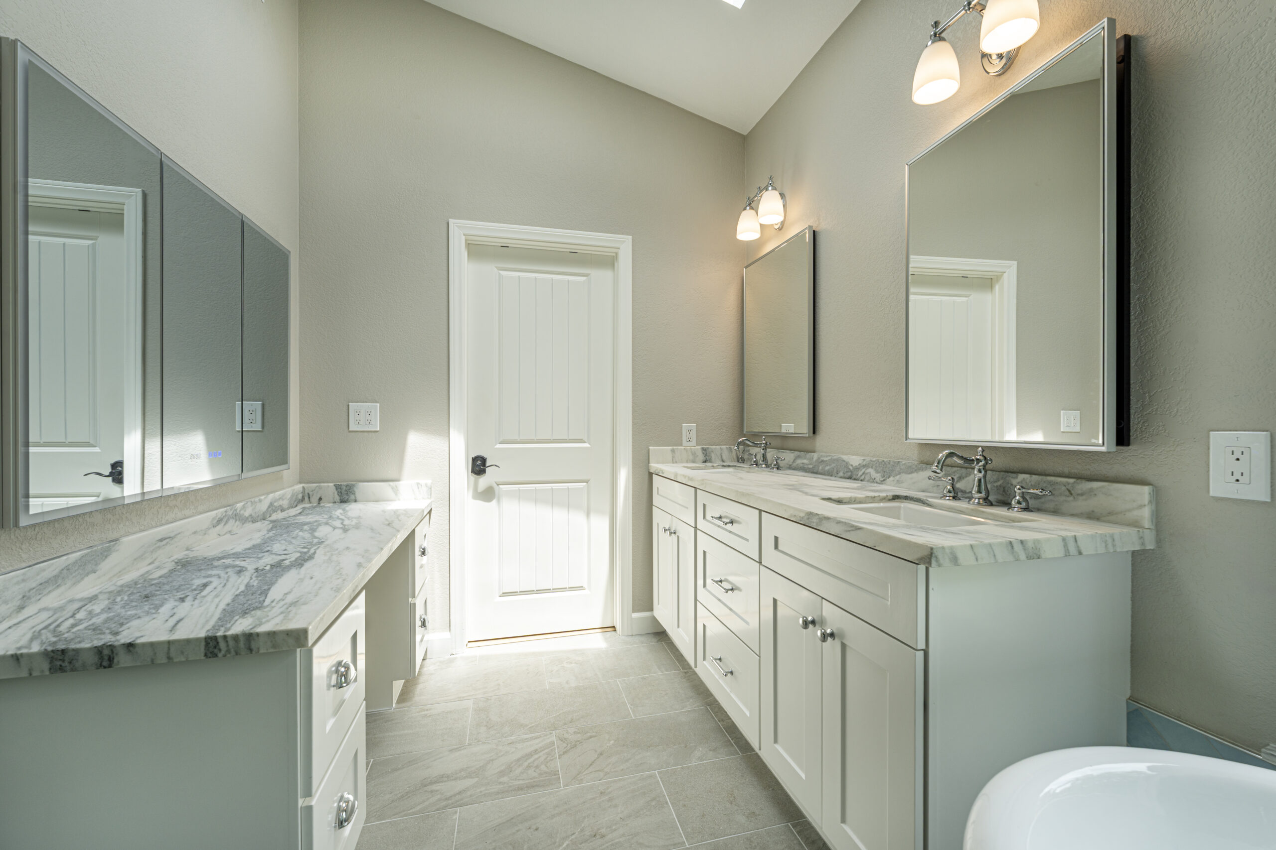 Two vanities and linen closet in this master bathroom remodel.
