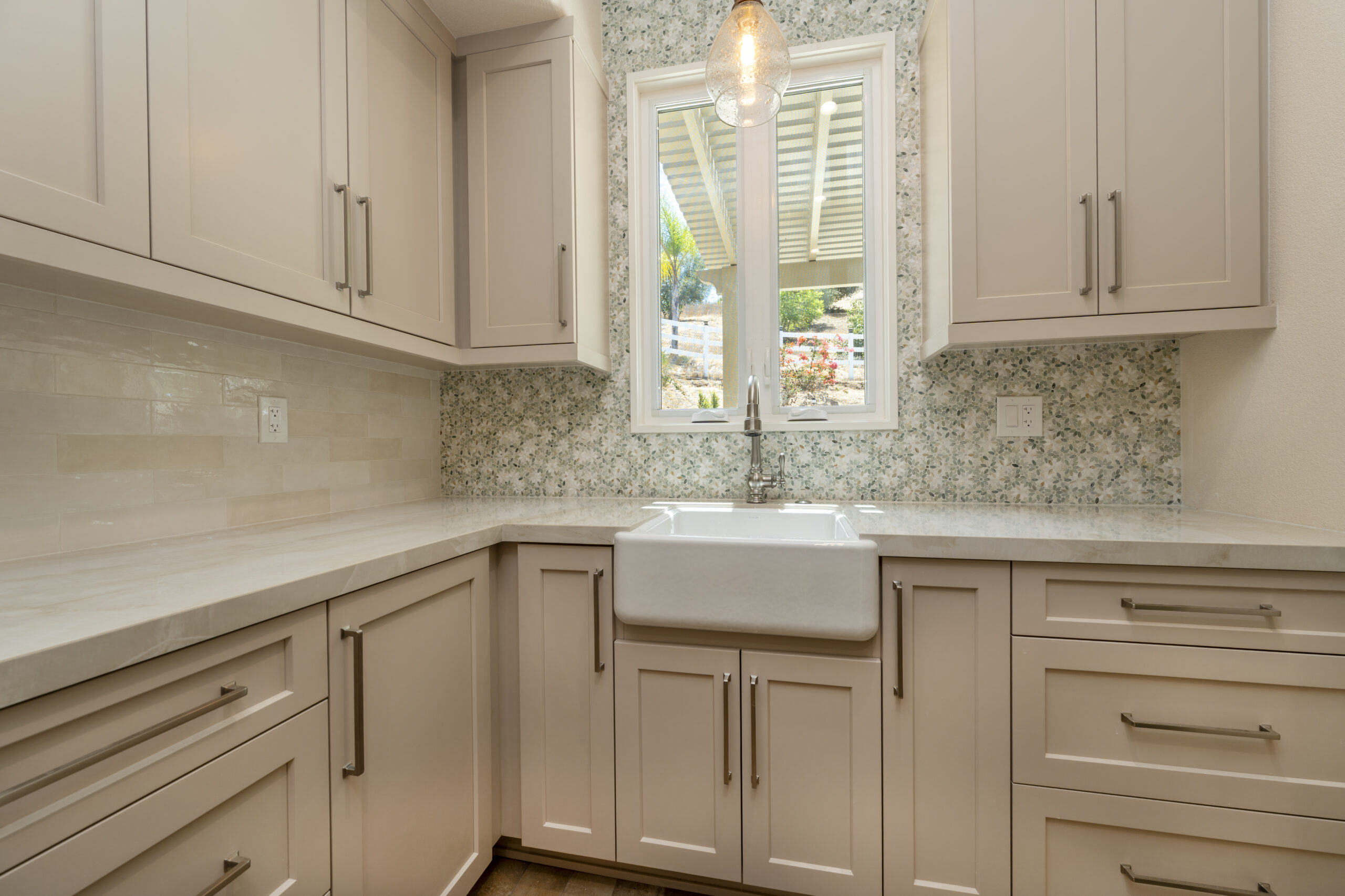 Custom walk-in pantry with cabinets, window, and apron front sink.