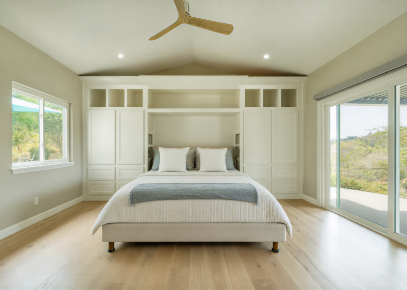 Master bedroom remodel with new windows and custom headboard cabinets.